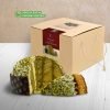 Bronte store pistachio panettone filled with pistachio cream, on a wooden table with white boards, in a room with a coffee-coloured wall.